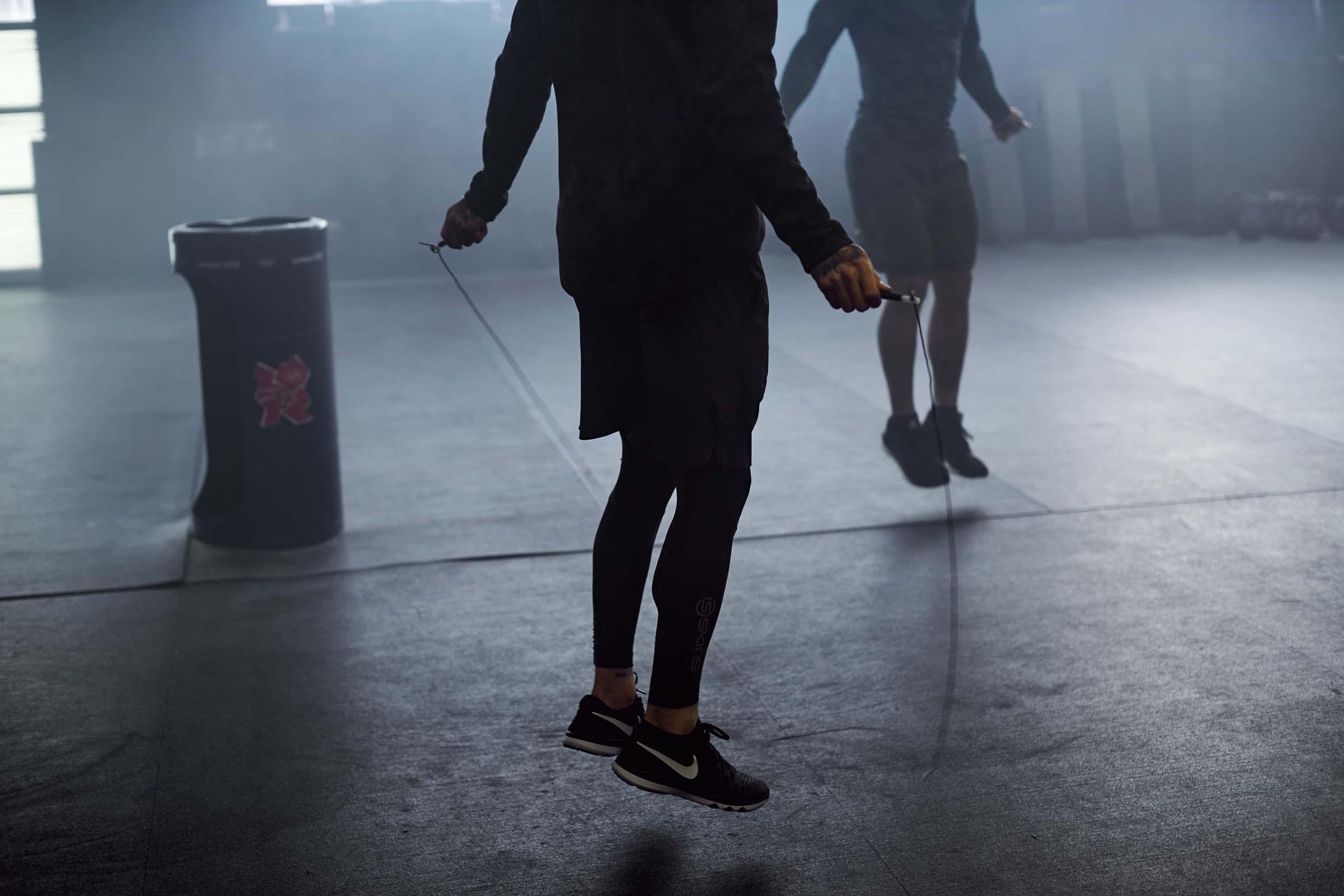 Ein Mann traininert mit einem Springseil.