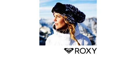 Eine Frau in Skiklamotten in einer bergigen winterlichen Landschaft