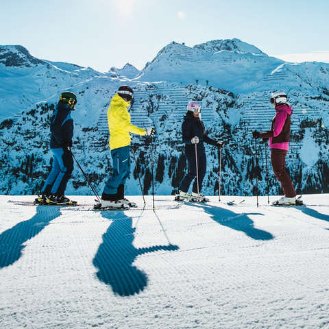 Eine Gruppe Skifahrer macht sich zur Abfahrt bereit.