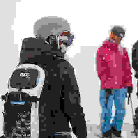 Eine Gruppe Skifahrer macht sich zur Abfahrt bereit.