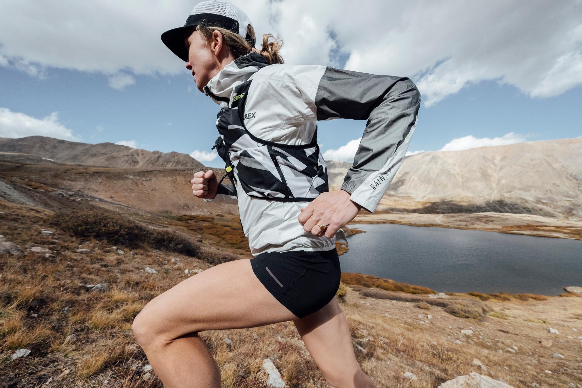 Frau tr&auml;gt adidas Schuhe beim Lauf &uuml;ber steinigen Untergrund.