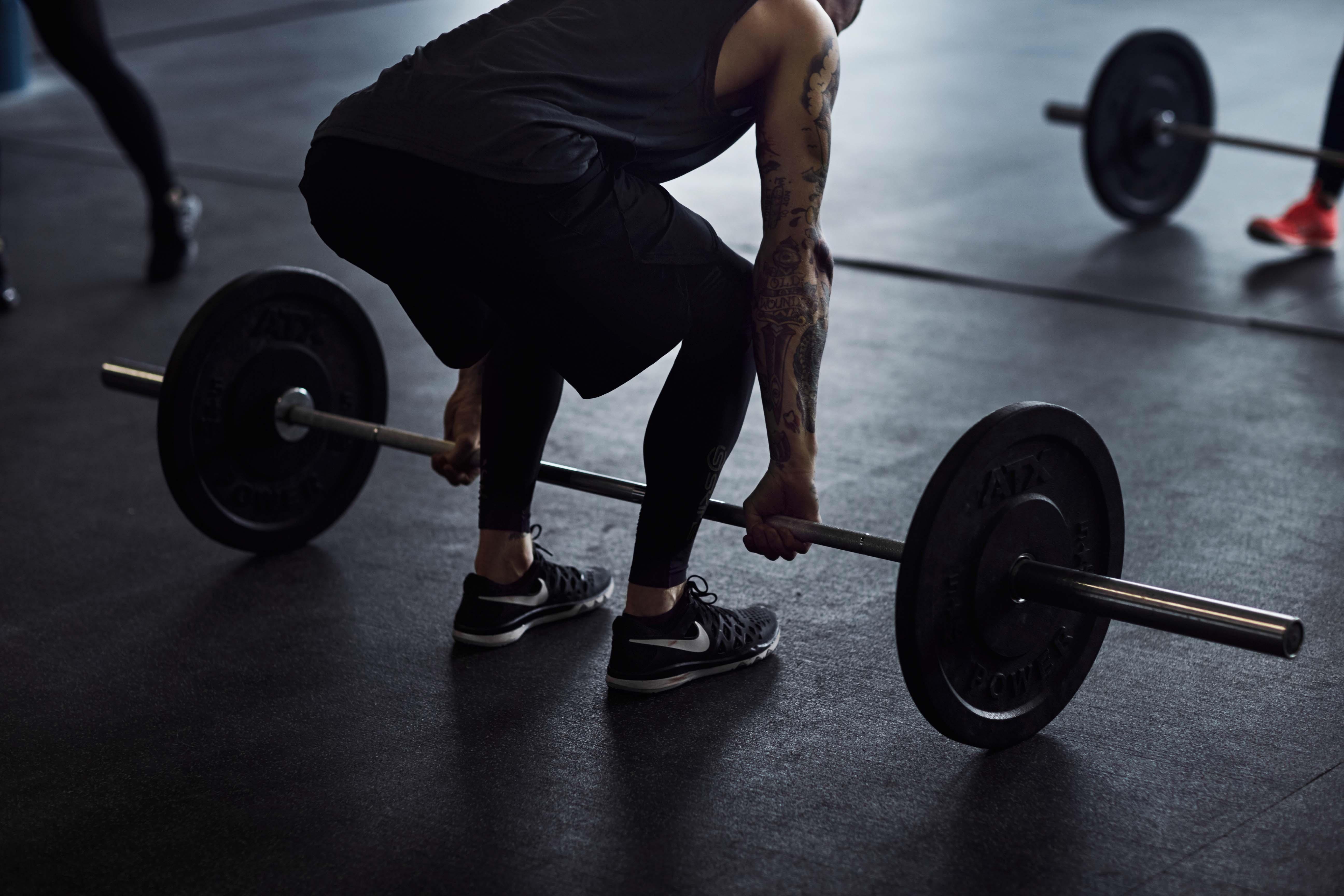 Ein Mann und eine Frau trainieren in einem Crossfitstudio mit Langhanteln die &Uuml;bung Kreuzheben.