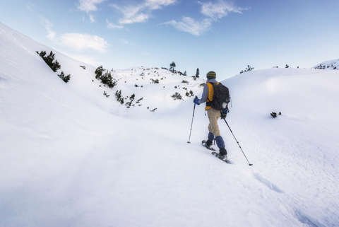 Ein Schneeschuhwanderer geht im Frontalschritt.