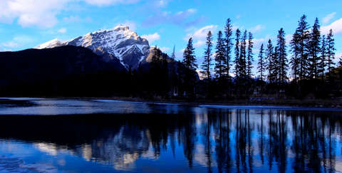 Ein See in Kanada. Im Hintergrund ist ein schneebedeckter Berg zu sehen.
