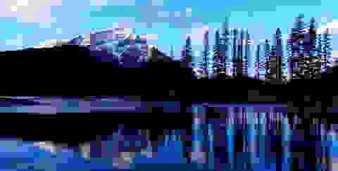 Ein See in Kanada. Im Hintergrund ist ein schneebedeckter Berg zu sehen.