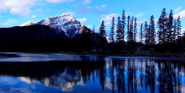 Ein See in Kanada. Im Hintergrund ist ein schneebedeckter Berg zu sehen.