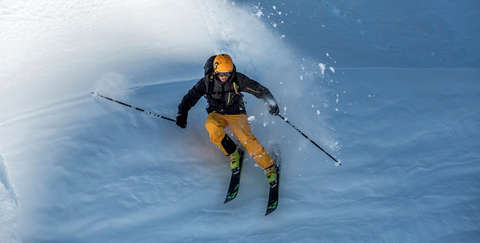 Ein Skifahrer bei der Abfahrt aus der Adler-Perspektive aufgenommen.