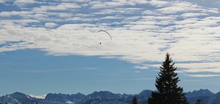Ein Paraglider am bewölkten Himmel.