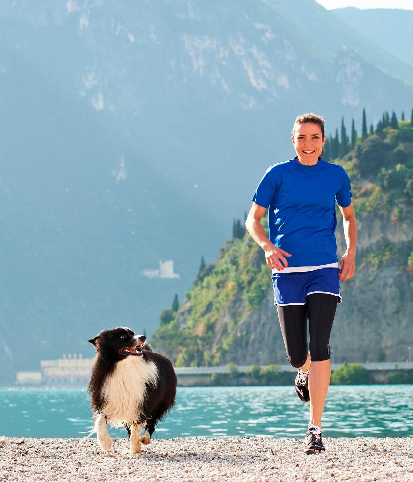 Sonja von Opel läuft mit ihrem Hund an einem See entlang