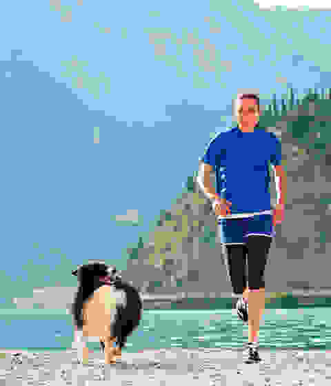Sonja von Opel läuft mit ihrem Hund an einem See entlang