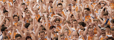 Viele Läufer stehen zusammen und recken die Hände zum feiern in die Höhe.