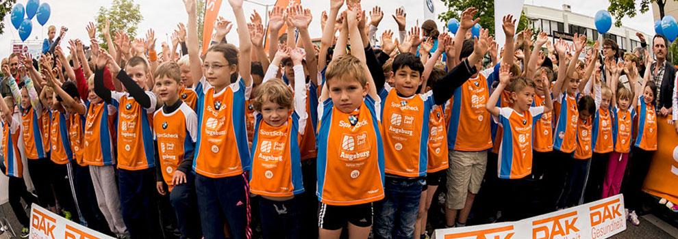 Viele Kinder strecken beim Stadtlauf Augsburg die Hände in den Himmel.