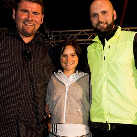 Eine Frau wird von 2 Männern umarmt beim SportScheck Nachtlauf Erfurt.