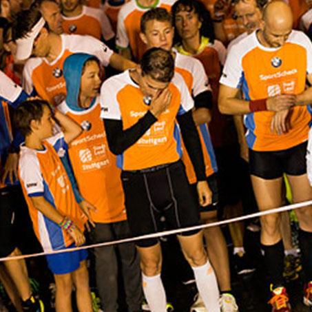 Eine Gruppe Läufer eines Stadtlaufs mit orange-weißen Shirts