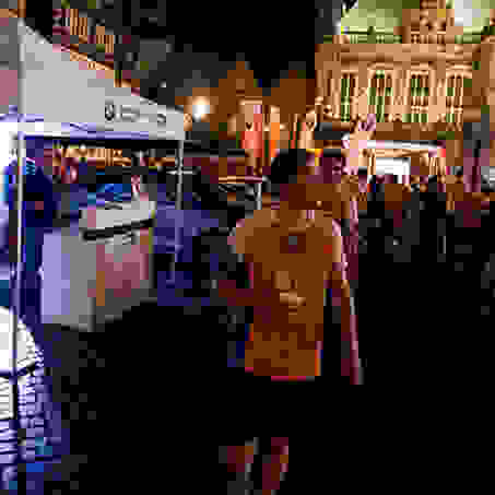 Ein Läufer steht beim Nachtlauf Bremen mit einem Becher Wasser in der Hand.