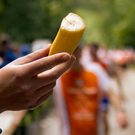 Eine Hand hält eine halbe Banana, die einem Läufer vom Stadtlauf Kassel gereicht wird.