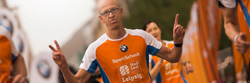 Ein Mann streckt nach dem Zieleinlauf die Finger in die H&ouml;he.