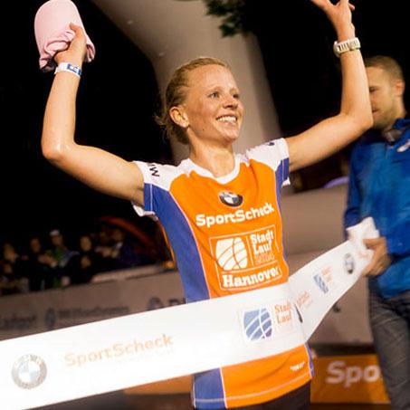 Eine Frau beim Zieldurchlauf beim Stadtlauf Hannover von SportScheck.