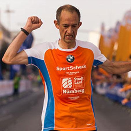 Ein Läufer beim Stadtlauf Nürnberg reckt die geballte Faust in den Himmel, als er im Ziel eingetroffen ist.