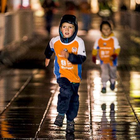 Ein kleiner Junge läuft durch den Regen während des Stuttgart Stadtlaufs für Kids.