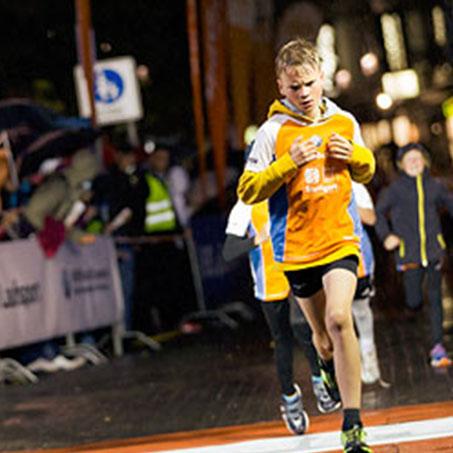 Ein Junge läuft bei einem abendlichen Stadtlauf mit