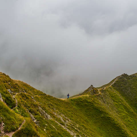 Ein Trailrunner läuft einen Trail über einen Bergkamm.