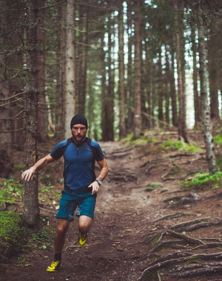 Ein Mann läuft im Wald einen Trail.