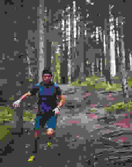 Ein Mann läuft im Wald einen Trail.