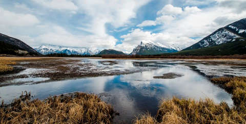 Eine wunderschöne Landschaftsaufnahme aus Kanada, die zum Wandern einlädt. Im Hintergrund sind verschneite Berge zu sehen.