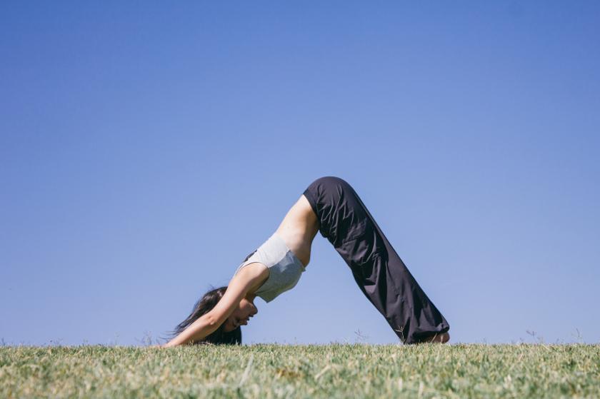 Eine Frau macht die Yogaübung "Der Hund" - Position 1