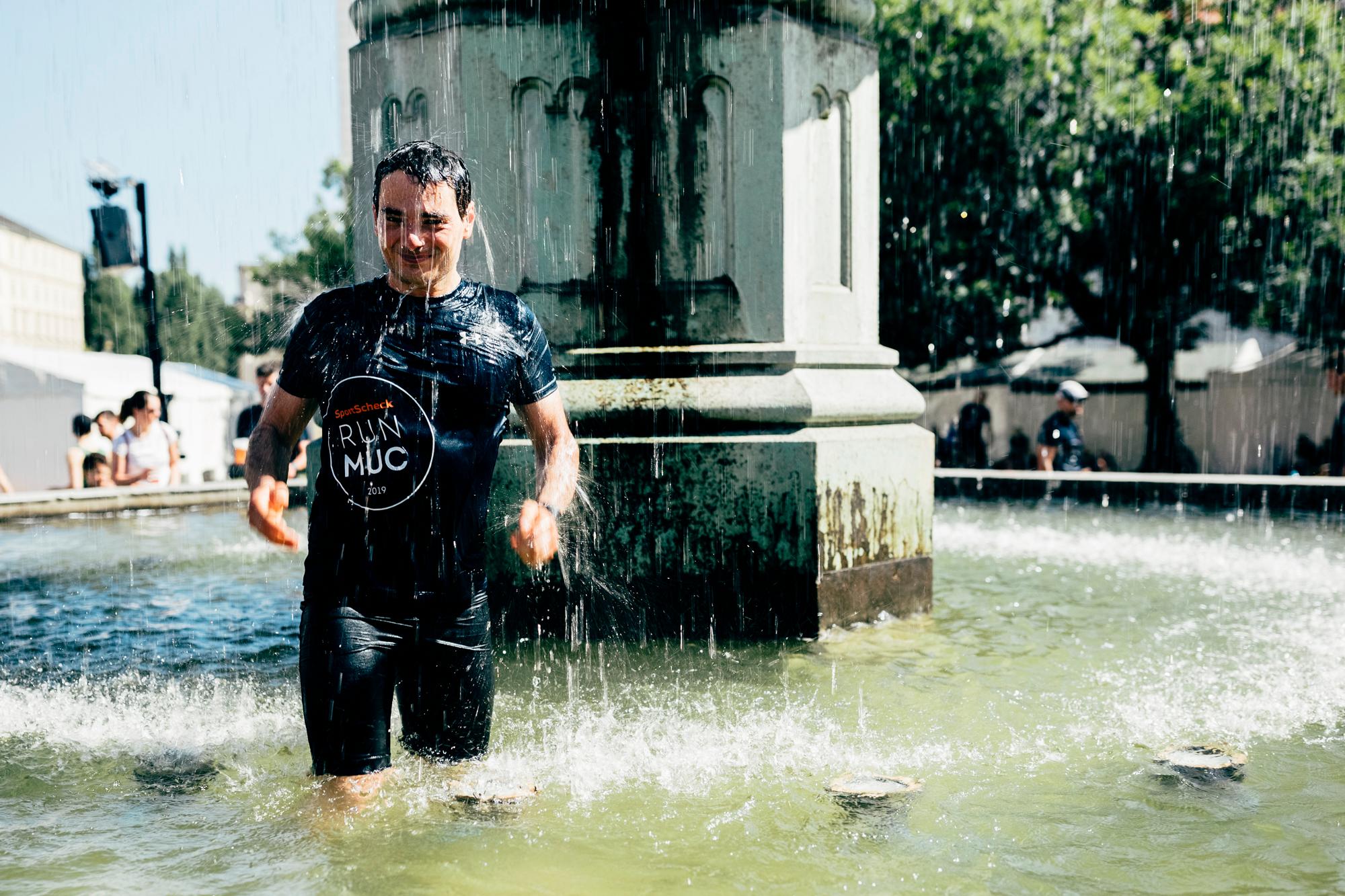 Ein L&auml;ufer k&uuml;hlt sich in einem Brunnen ab