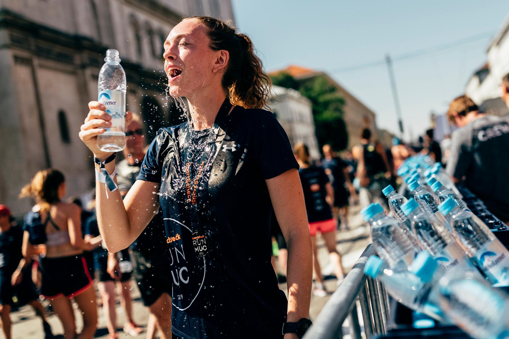 Eine Teilnehmerin des SportScheck RUNs M&uuml;nchen erfrischt sich nach dem Lauf