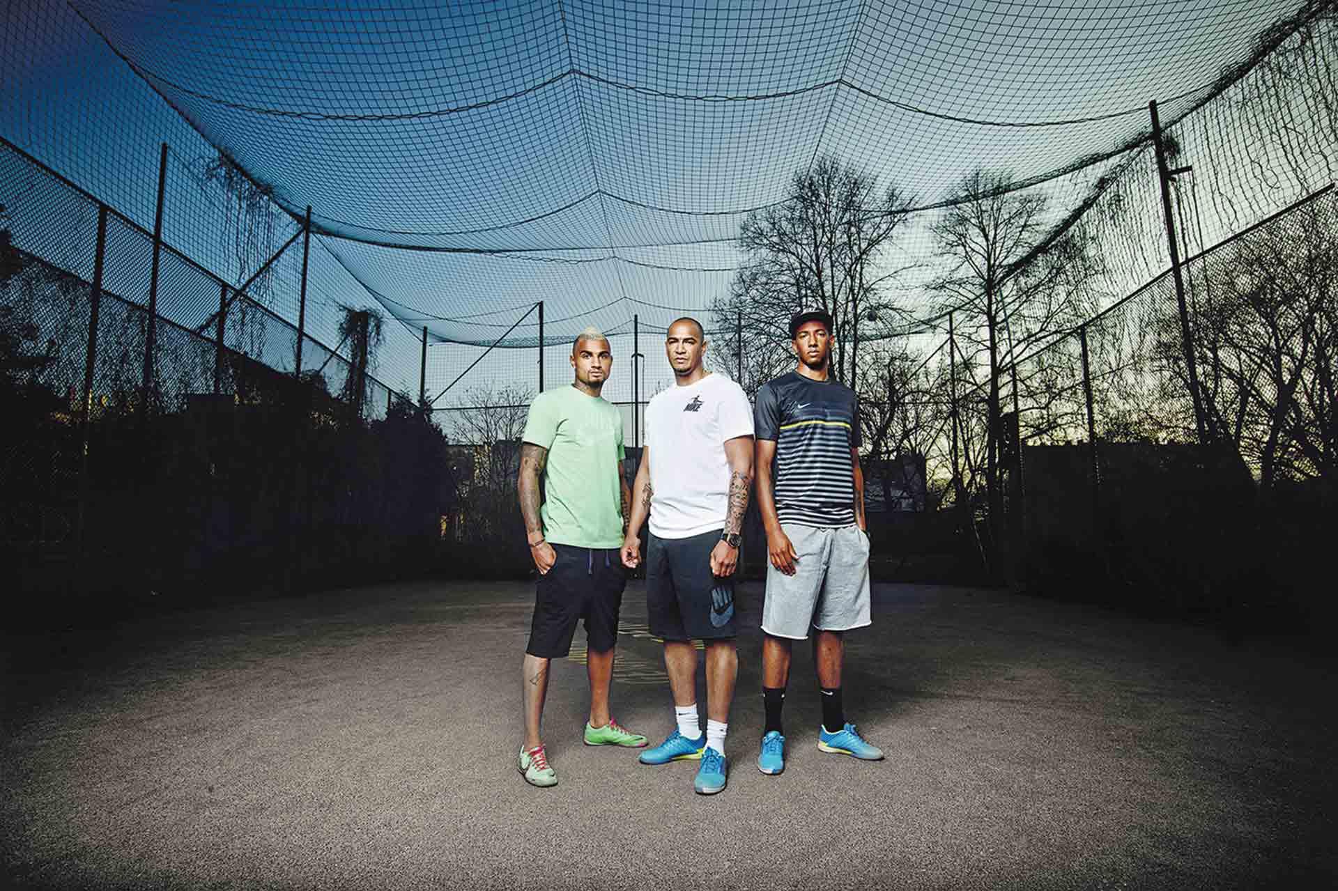 Jerome Boateng und seine beiden Br&uuml;der stehen auf einem Bolzplatz