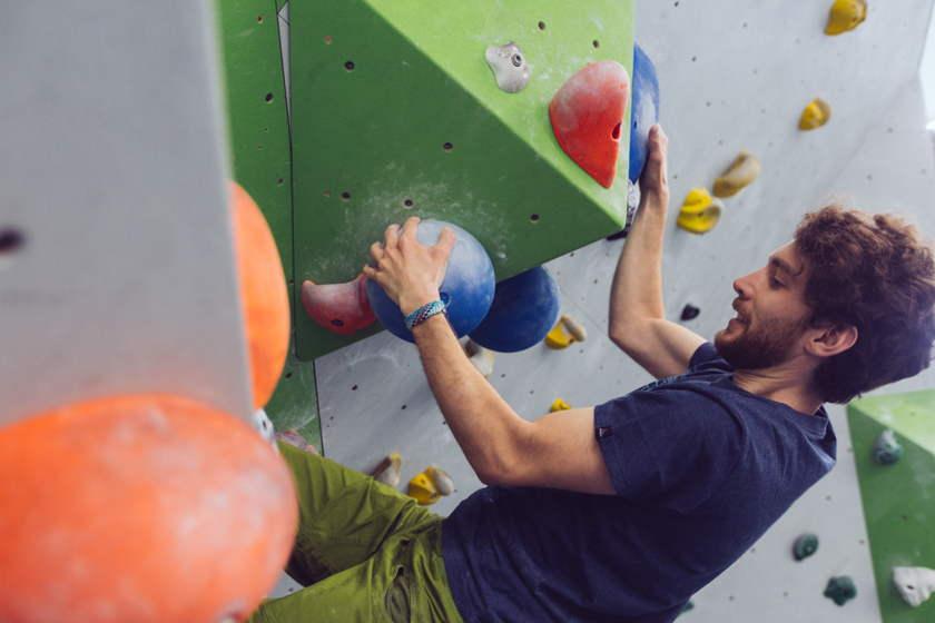 Ein Mann bouldert in der Kletterhalle