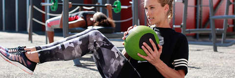 Eine Frau traininert Crunches mit einem Ball.