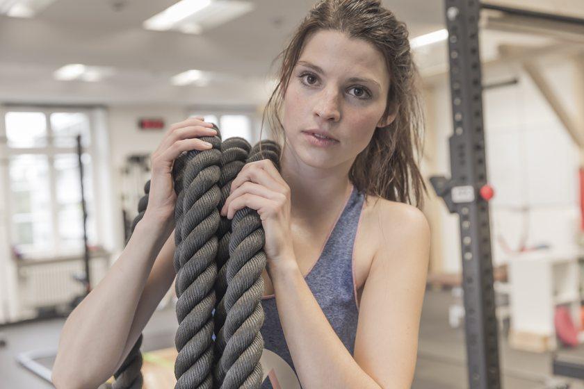 Im Fokus des Bildes ist die Hand eines Boulderers der die Greiftechnik Lochgriff beim klettern verwendet.