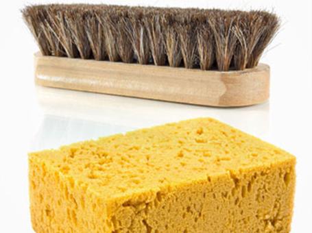 Ein gelber Putzschwamm und eine Schuhbürste zur Pflege der Gore Tex Schuhe.