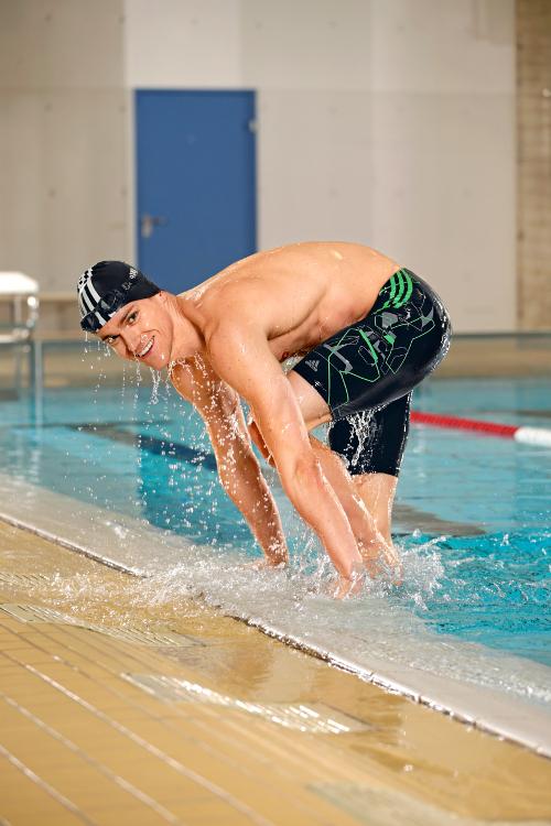 Ein Mann steigt aus einem Schwimmbecken. Er tr&auml;gt eine Jammer Badehose.