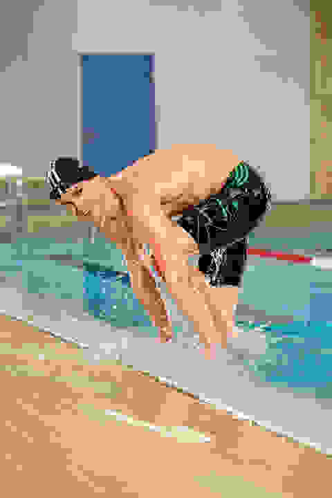 Ein Mann steigt aus einem Schwimmbecken. Er trägt eine Jammer Badehose.