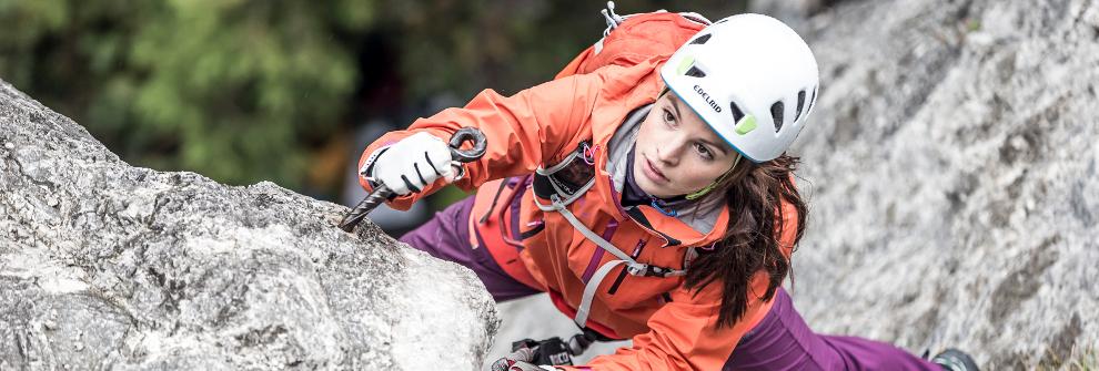 Eine Kletterin tr&auml;gt zu ihrer Sicherheit einen wei&szlig;en Kletterhelm.