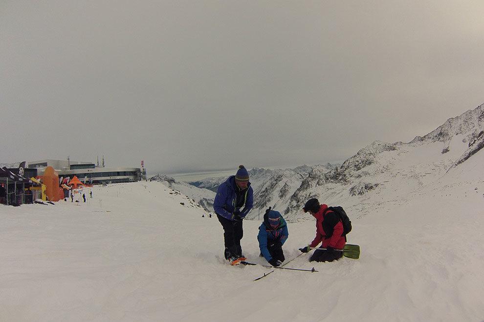 Die Gruppe &uuml;bt die Feinsuche. Sie bilden mit ihren Skist&ouml;cken ein Kreuz und 