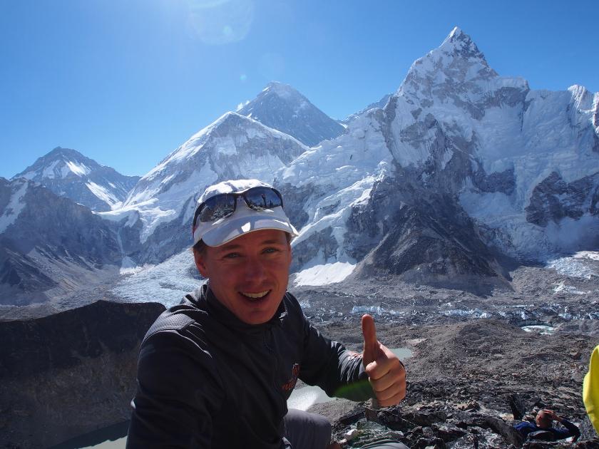 Extremläufer Michele Ufer streckt den Damen nach oben in einer alpinen sonnigen Berglandschaft