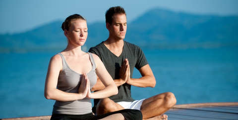 Ein Mann und eine Frau beim Yoga in organischer Yoga Kleidung.