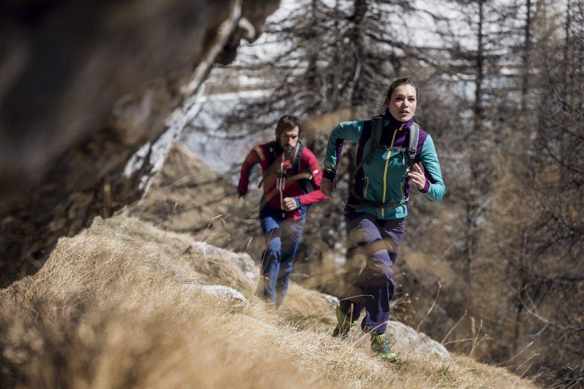 Ein Paar beim Trailrunning am Berg bei Herbstwetter