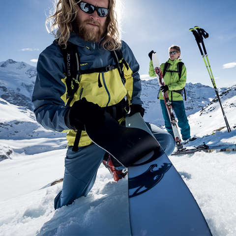 Ein Mann und eine Frau in voller Skitourenbekleidung auf einem Berg.