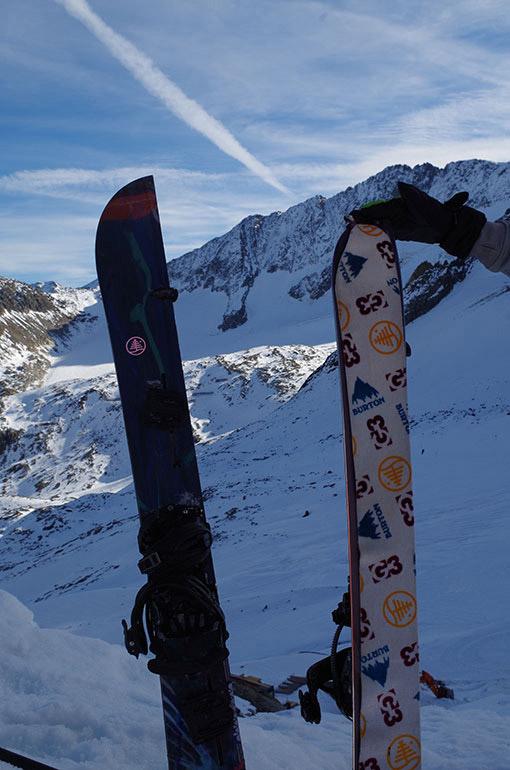 2 Splitboards stecken hochkant im Schnee. Sie sind jeweils mit einem Fell überzogen.