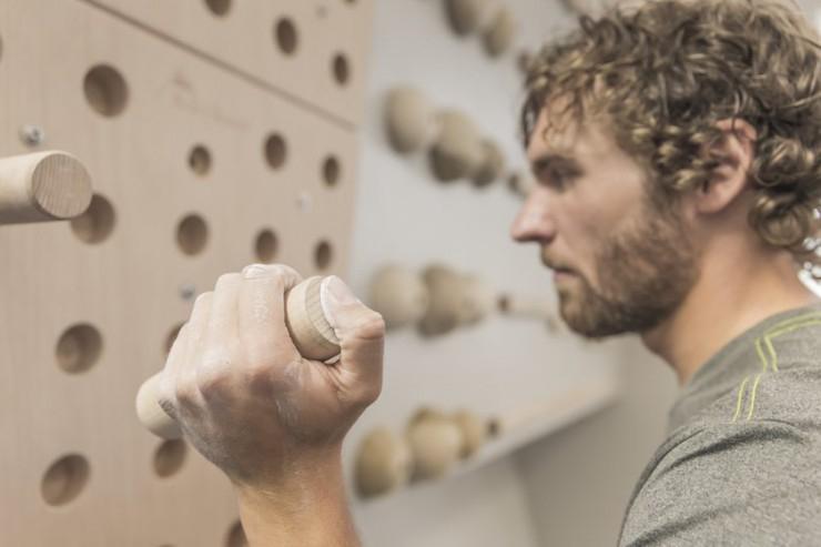 Ein Mann trainiert f&uuml;rs Bouldern an einem Steckbrett