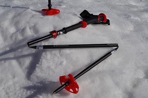 Ein Teleskopstock liegt im Schnee. Die einzelnen Glieder des Stocks sind deutlich zu erkennen.