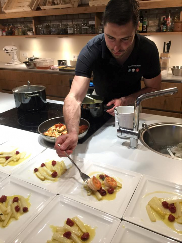 Ein Mann kocht Spargel und Garnelen