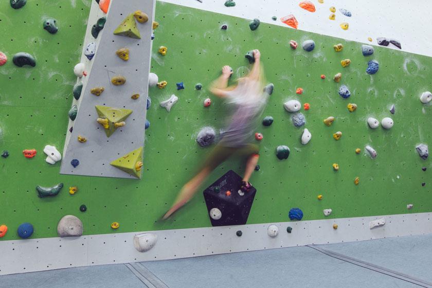 Ein Mann beim Bouldern in einer Kletterhalle.